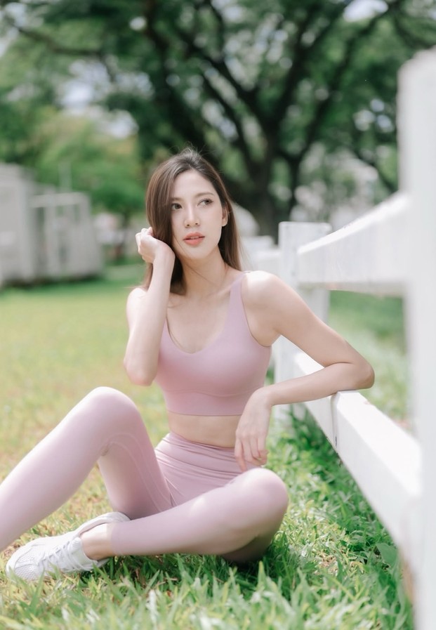 Nuknik Panatda ในชุดออกกำลังกายสีชมพูน่ารัก นั่งโพสท่าสดใสริมรั้วสีขาว